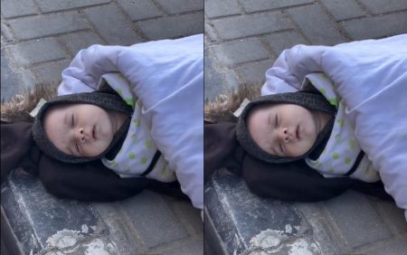 A baby lying on the ground in freezing cold weather