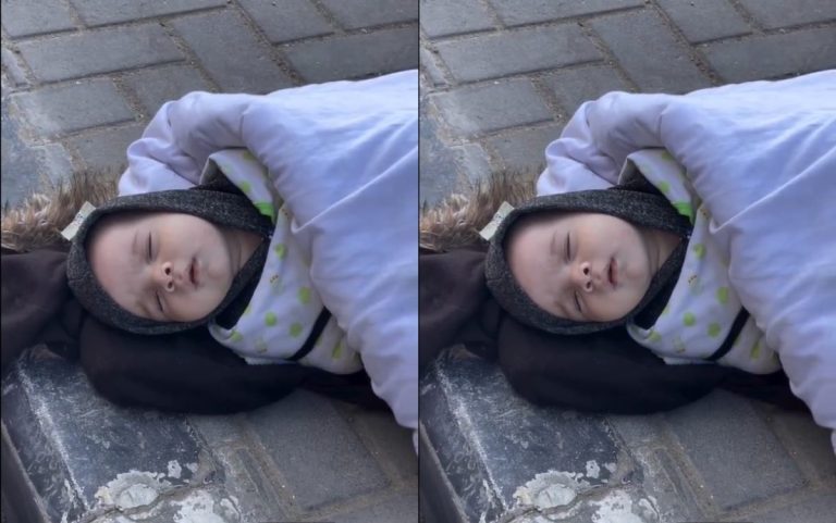 A baby lying on the ground in freezing cold weather