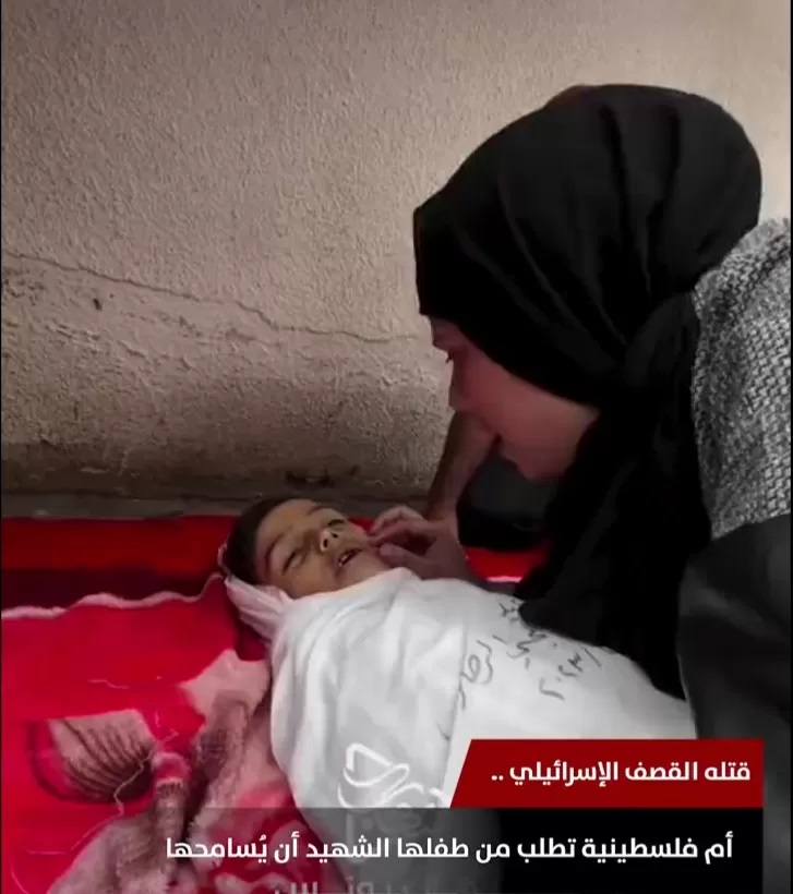 Gaza’s Tragedy Unveiled: A Mother’s Anguish Beside Her Martyred Child, Begging for Forgiveness